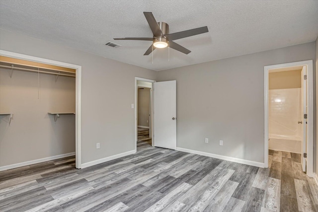 unfurnished bedroom with ceiling fan, a closet, a textured ceiling, and light wood-type flooring