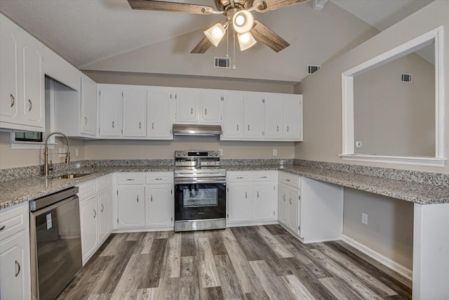 kitchen featuring appliances with stainless steel finishes, white cabinetry, and lofted ceiling