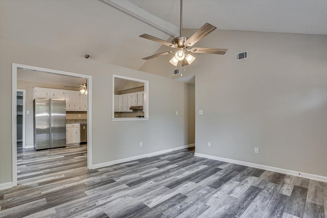 unfurnished room with vaulted ceiling with beams and light wood-type flooring