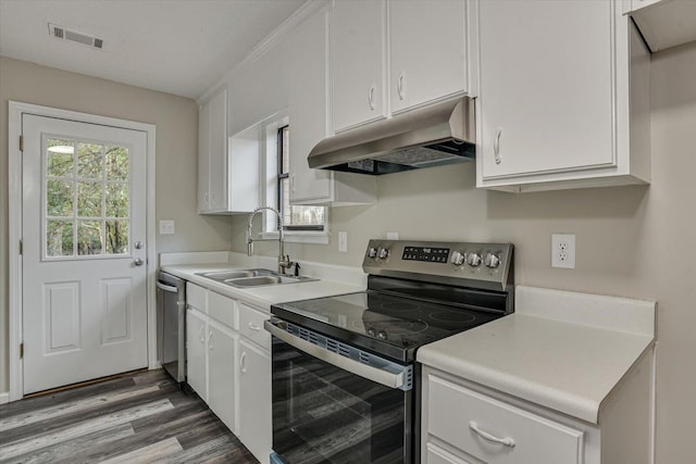 kitchen with white cabinets, appliances with stainless steel finishes, wood-type flooring, and sink