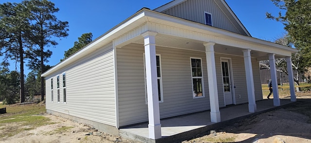 view of side of property featuring covered porch