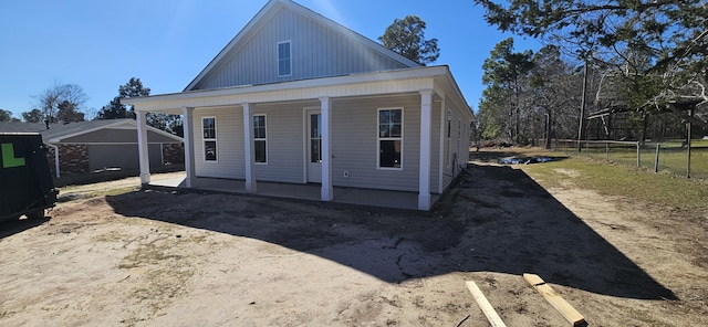 view of front of home featuring covered porch and fence