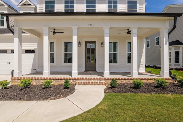doorway to property featuring covered porch, a garage, ceiling fan, and a lawn
