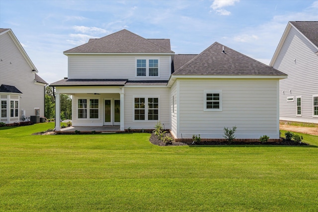 rear view of property with roof with shingles, a yard, ceiling fan, and a patio