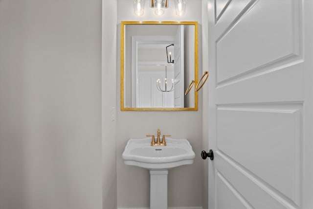 bathroom featuring a sink and a chandelier