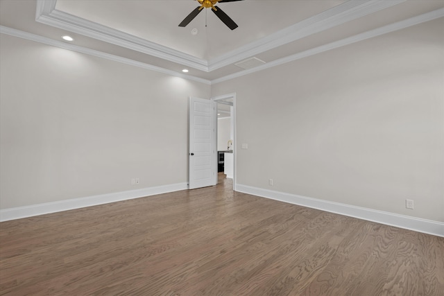 unfurnished room with a ceiling fan, wood finished floors, a raised ceiling, recessed lighting, and crown molding