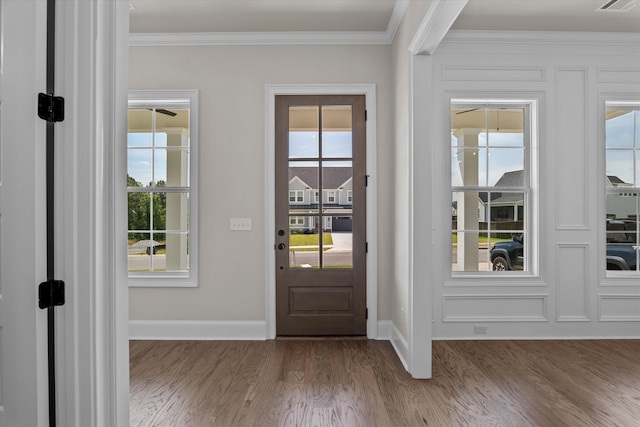 entryway featuring wood finished floors, ornamental molding, and baseboards