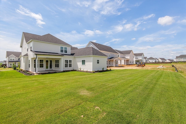 rear view of house with a patio area, a yard, and a residential view