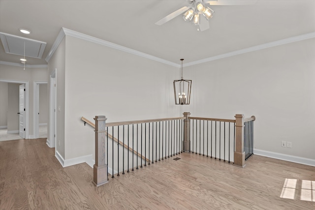 hallway featuring attic access, an upstairs landing, ornamental molding, wood finished floors, and baseboards