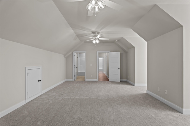 bonus room featuring ceiling fan, light carpet, vaulted ceiling, and baseboards