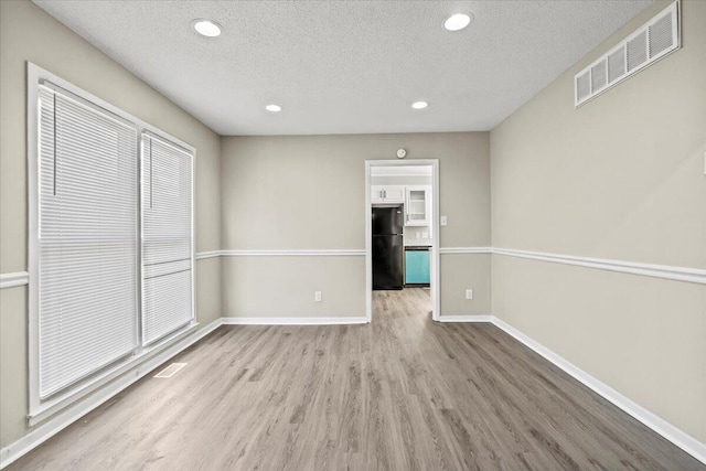 interior space featuring a textured ceiling and light hardwood / wood-style floors