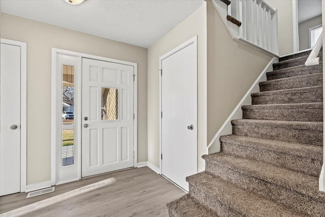 entrance foyer with hardwood / wood-style flooring and a textured ceiling