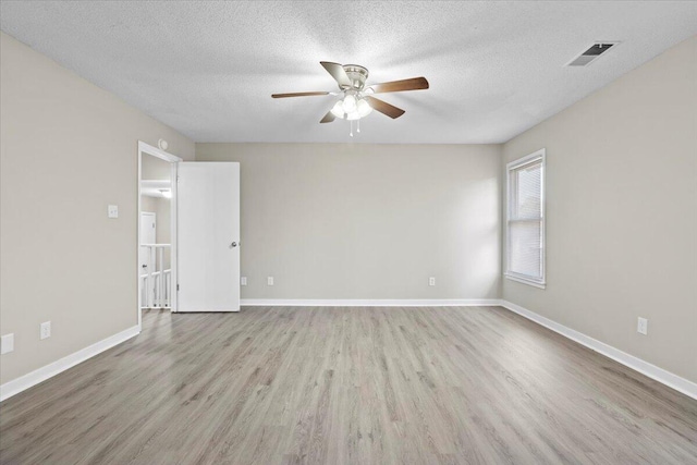 empty room featuring ceiling fan, light hardwood / wood-style floors, and a textured ceiling