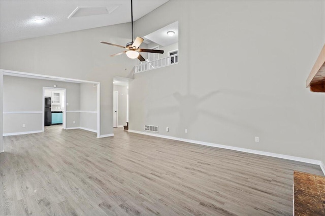 unfurnished living room with ceiling fan, high vaulted ceiling, and light hardwood / wood-style floors