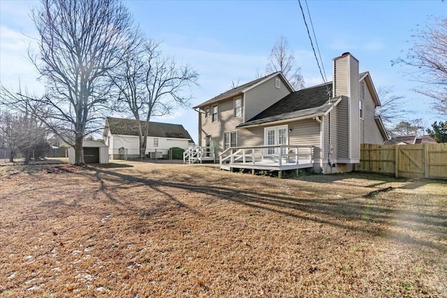 back of property with a lawn, a deck, and a storage unit