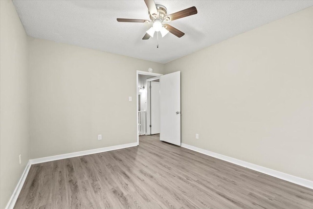 empty room with ceiling fan, a textured ceiling, and light wood-type flooring