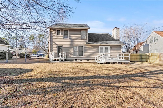 rear view of house with a wooden deck, a yard, and french doors