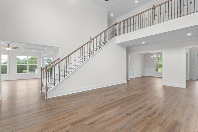 309 Militia Loop, North Augusta, SC 29860 - unfurnished living room featuring ceiling fan, crown molding, a high ceiling, stairway, and wood finished floors