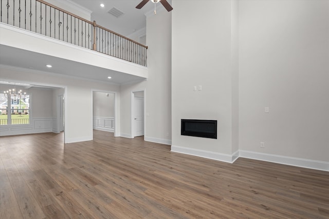 309 Militia Loop, North Augusta, SC 29860 - unfurnished living room with a ceiling fan, a glass covered fireplace, wood finished floors, a chandelier, and ornamental molding