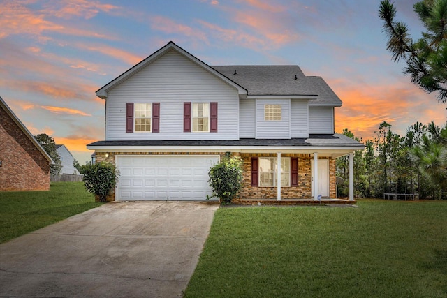 view of front of home with a porch, a yard, and a garage