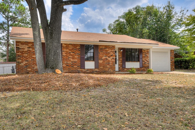 ranch-style house featuring a front yard, a garage, and covered porch