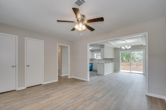 unfurnished dining area with wooden walls, a textured ceiling, light hardwood / wood-style floors, and a notable chandelier