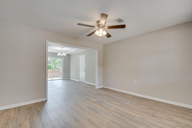 unfurnished room featuring ceiling fan with notable chandelier, a textured ceiling, and light wood-type flooring