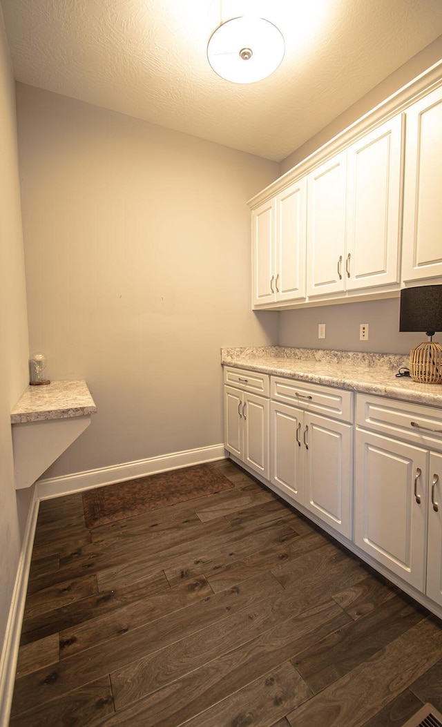 laundry area with dark hardwood / wood-style flooring