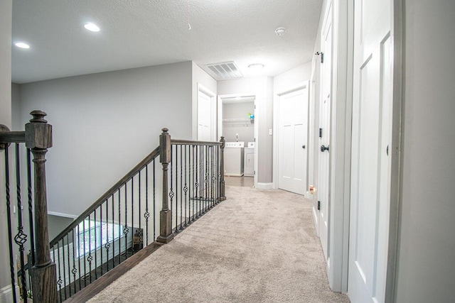 corridor featuring carpet flooring and washer and clothes dryer