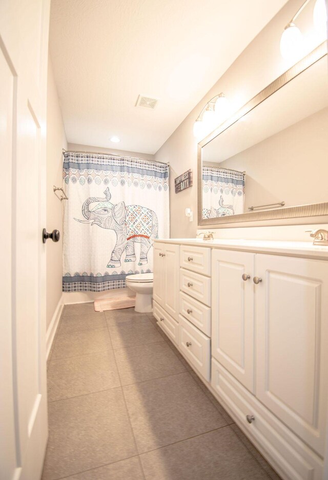 bathroom featuring walk in shower, tile patterned flooring, vanity, and toilet