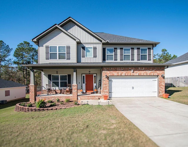 craftsman-style house with covered porch, a garage, and a front yard