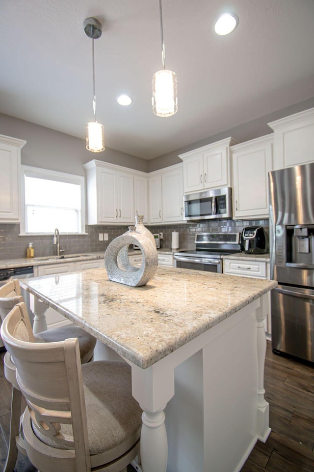1144 Bubbling Springs Dr, Graniteville, SC 29829 - kitchen with backsplash, a kitchen island, appliances with stainless steel finishes, white cabinets, and dark wood-style flooring