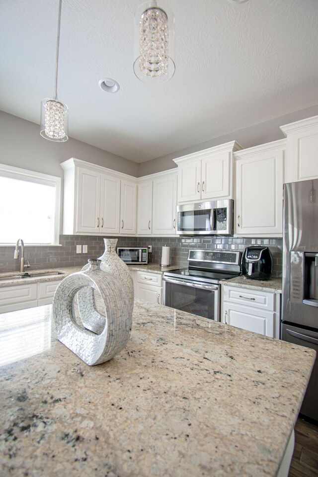 kitchen featuring appliances with stainless steel finishes, tasteful backsplash, white cabinets, dark hardwood / wood-style floors, and a kitchen island