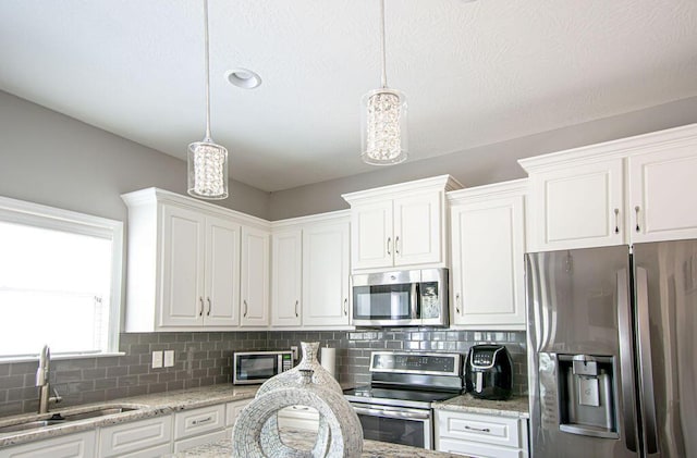 1144 Bubbling Springs Dr, Graniteville, SC 29829 - kitchen with a sink, decorative light fixtures, backsplash, stainless steel appliances, and white cabinets