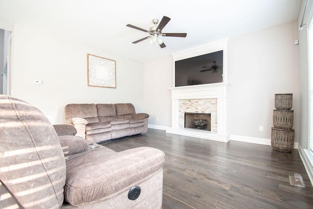 living room with dark hardwood / wood-style floors, ceiling fan, and a tiled fireplace