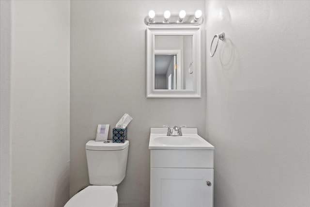 half bath featuring vanity and toilet