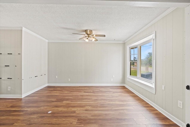 unfurnished room featuring crown molding, baseboards, ceiling fan, and wood finished floors
