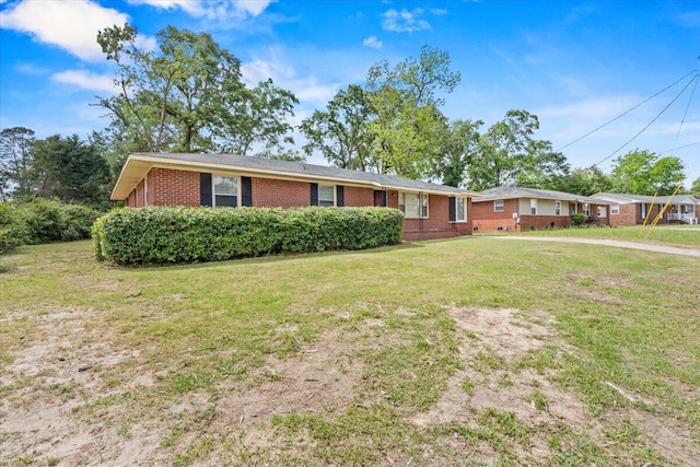 ranch-style house with brick siding and a front yard