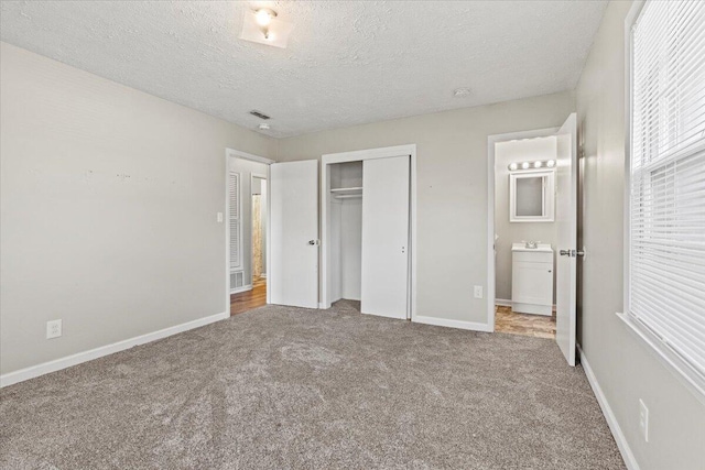 unfurnished bedroom featuring baseboards, carpet, a closet, and a textured ceiling