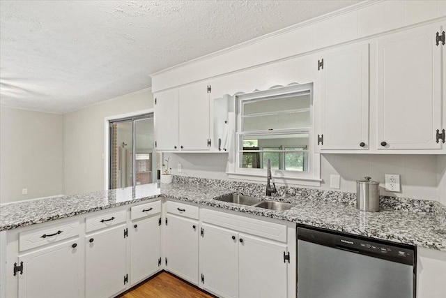 kitchen featuring stainless steel dishwasher, a peninsula, a textured ceiling, white cabinetry, and a sink