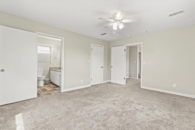 unfurnished bedroom featuring carpet flooring, baseboards, visible vents, and ensuite bath