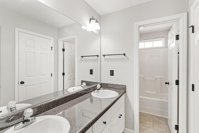 bathroom with double vanity, tile patterned flooring, a bathtub, and a sink