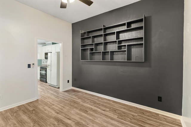 spare room with a ceiling fan, baseboards, and wood finished floors