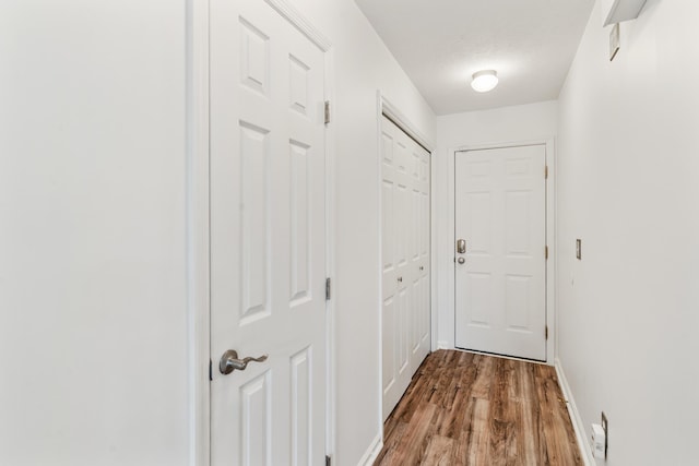 hallway featuring dark wood-style floors and baseboards