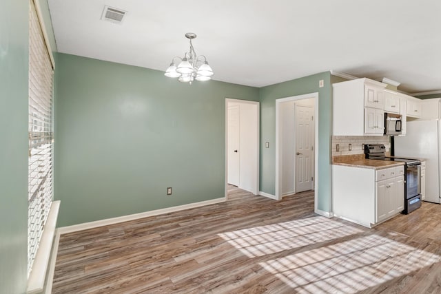 kitchen with a notable chandelier, light wood-style flooring, tasteful backsplash, stainless steel range with electric cooktop, and white cabinets