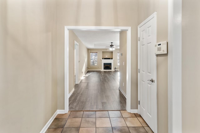 hall featuring baseboards and tile patterned flooring