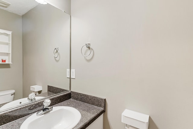 bathroom featuring visible vents, toilet, and vanity