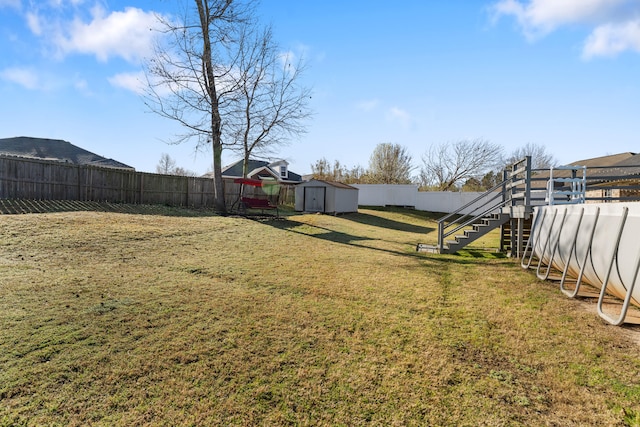 view of yard featuring a storage unit, an outbuilding, and a fenced backyard