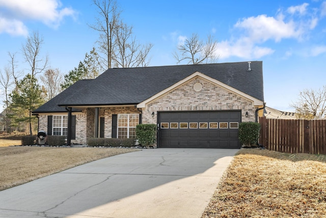 view of front of house with driveway, fence, a shingled roof, a garage, and brick siding