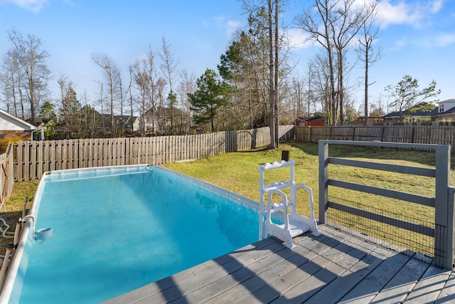 view of pool with a fenced backyard, a lawn, and a deck